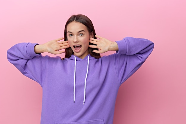 Photo portrait of smiling young woman standing against pink background