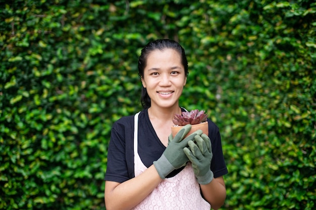 Portrait of smiling young woman standing against plants