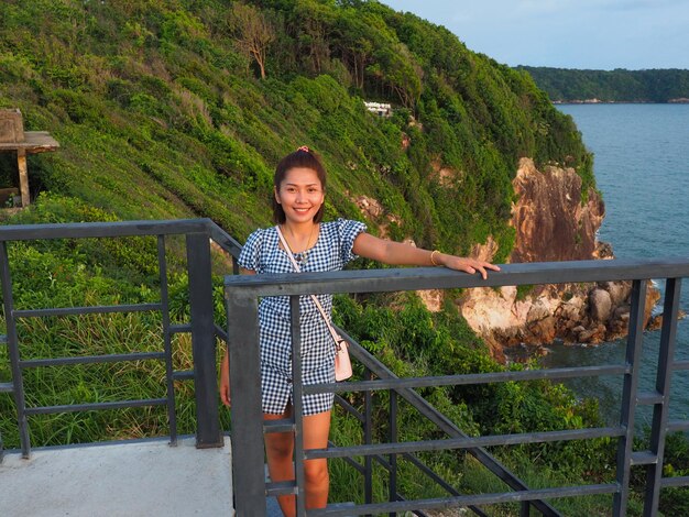 Photo portrait of smiling young woman standing against railing