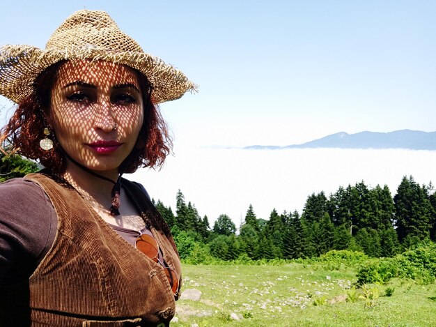 Foto ritratto di una giovane donna sorridente in piedi contro il cielo