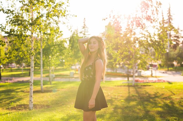 Photo portrait of smiling young woman standing against trees