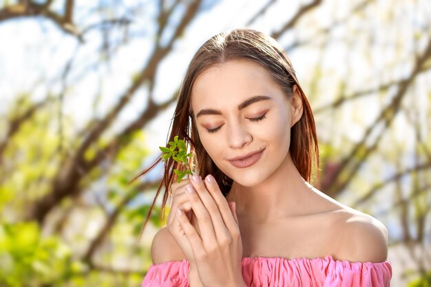 Portrait of smiling young woman standing against trees