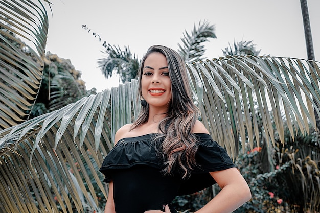 Portrait of smiling young woman standing against trees