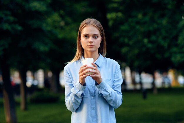 Портрет улыбающейся молодой женщины, стоящей на деревьях
