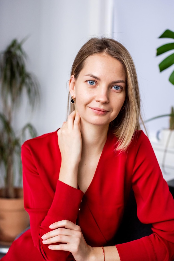 Фотография портрет улыбающейся молодой женщины, стоящей у стены