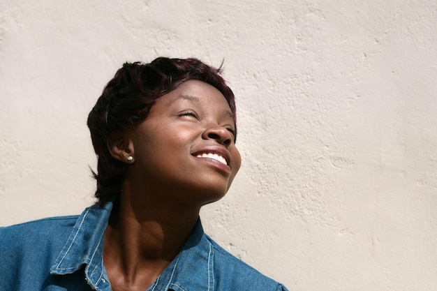 Photo portrait of smiling young woman standing against wall