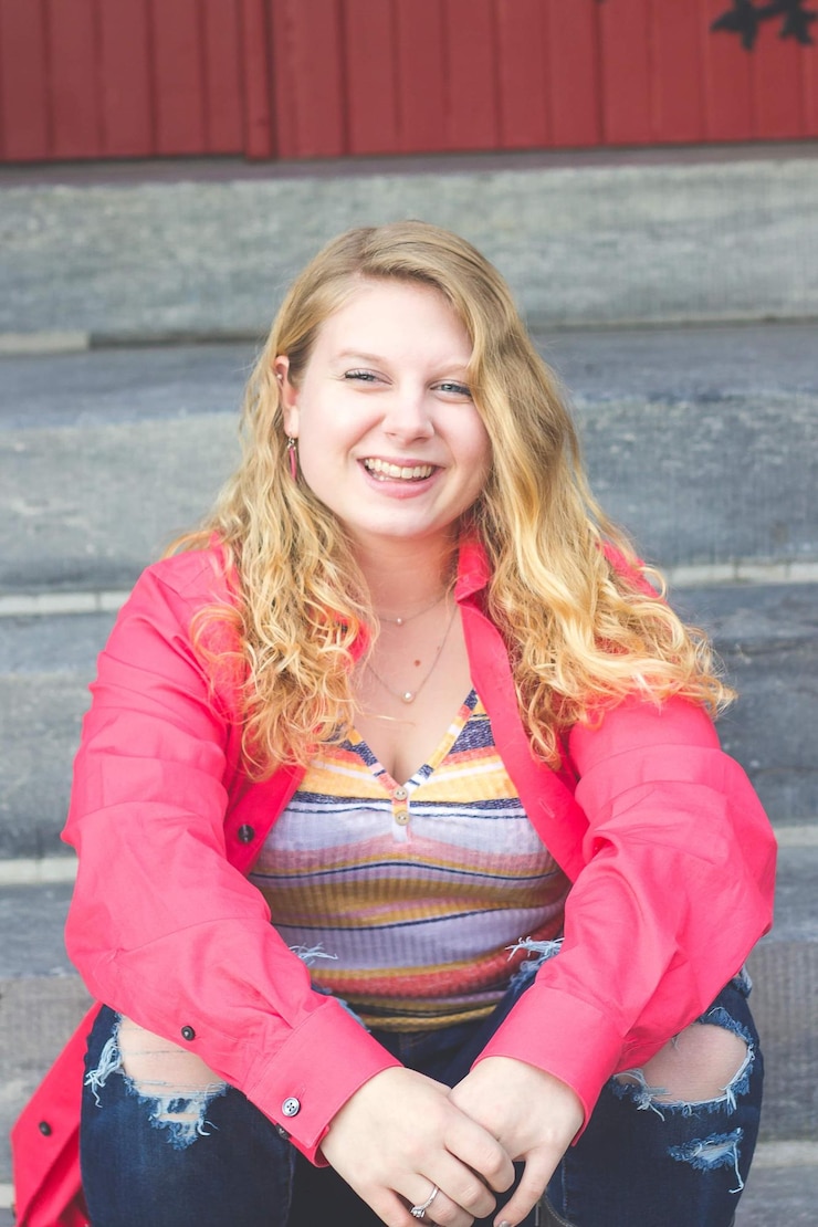 Photo portrait of smiling young woman standing against wall