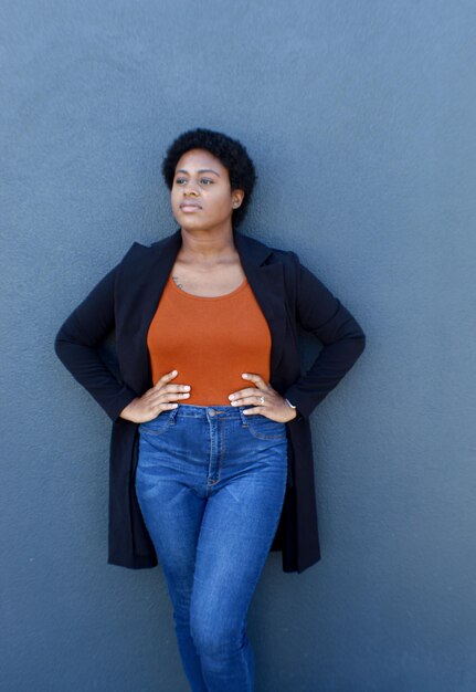 Photo portrait of a smiling young woman standing against wall