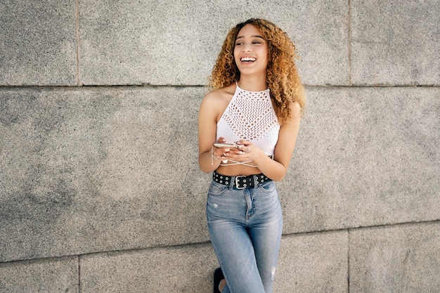 Photo portrait of smiling young woman standing against wall