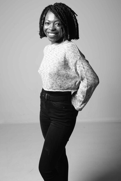 Photo portrait of smiling young woman standing against wall