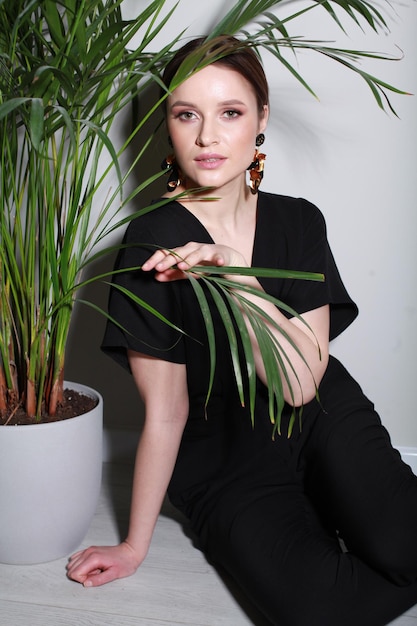 Portrait of smiling young woman standing against wall