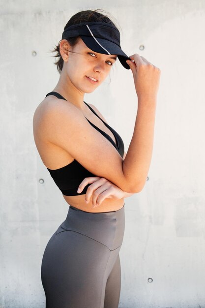 Portrait of smiling young woman standing against wall