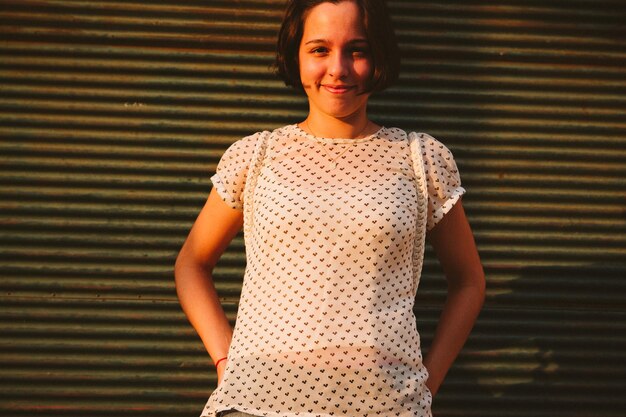 Photo portrait of smiling young woman standing against wall