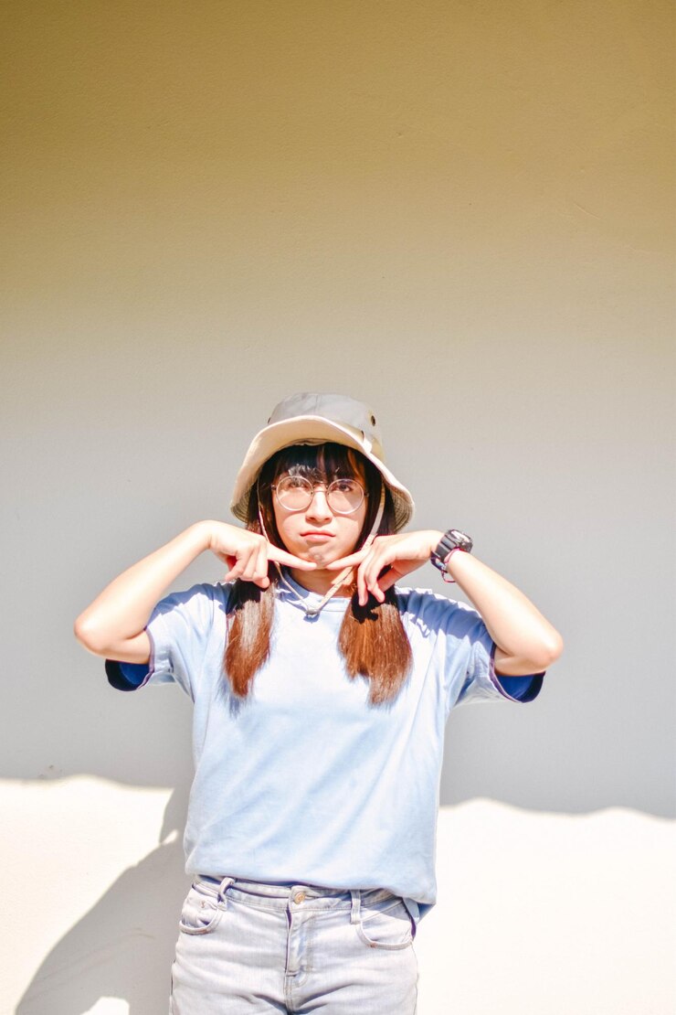 Photo 壁に寄り添って笑顔の若い女性の肖像画