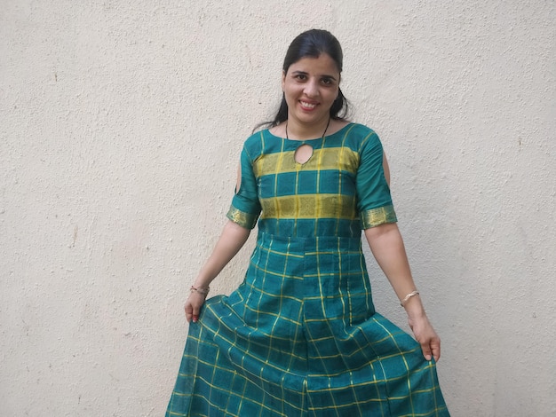 Portrait of a smiling young woman standing against wall