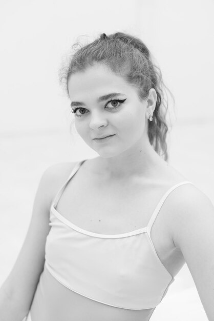 Photo portrait of a smiling young woman standing against white background