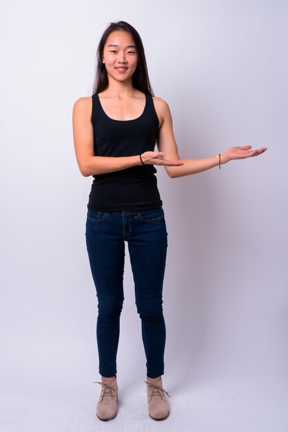 Photo portrait of smiling young woman standing against white background