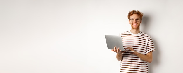 Photo portrait of smiling young woman standing against white background