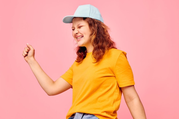 Photo portrait of smiling young woman standing against yellow background