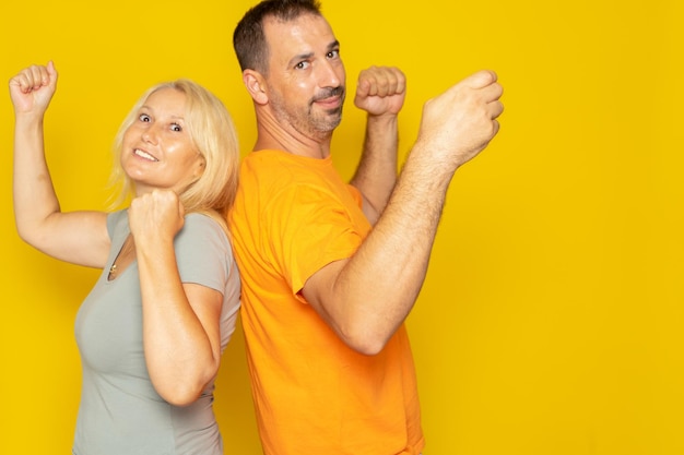 Portrait of smiling young woman standing against yellow background