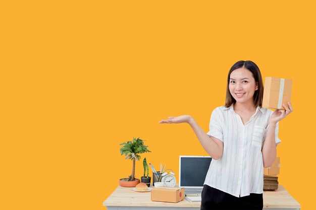 Portrait of a smiling young woman standing against yellow wall