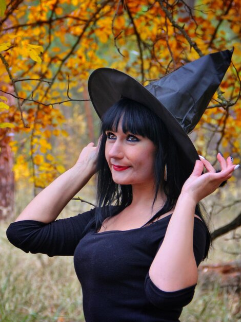 Portrait of smiling young woman standing during autumn