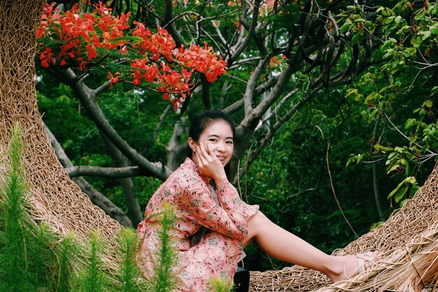 Photo portrait of smiling young woman standing by plants