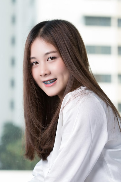 窓のそばに立っている笑顔の若い女性の肖像画