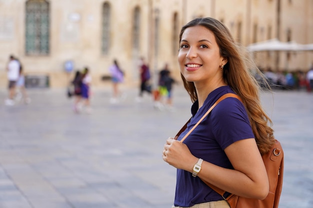 Photo portrait of smiling young woman standing in city