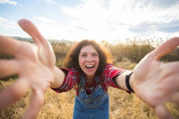 Foto ritratto di una giovane donna sorridente in piedi sul campo contro il cielo