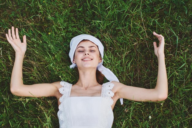 Foto ritratto di una giovane donna sorridente in piedi su un campo erboso