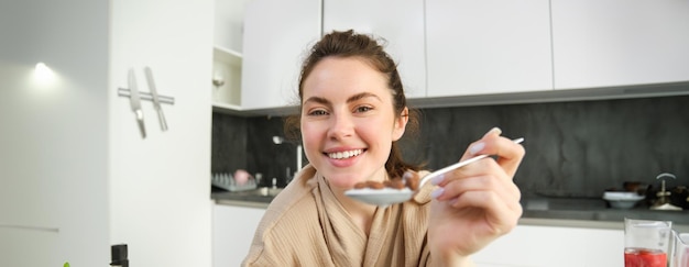 Portrait of smiling young woman standing at home