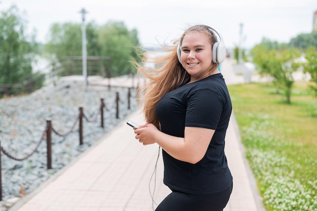 Photo portrait of smiling young woman standing on mobile phone