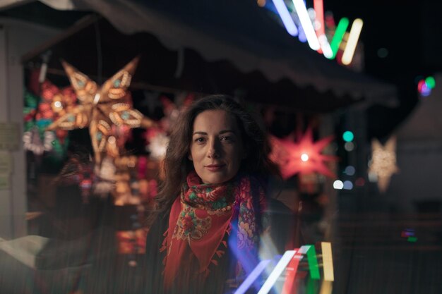 Photo portrait of smiling young woman standing at night