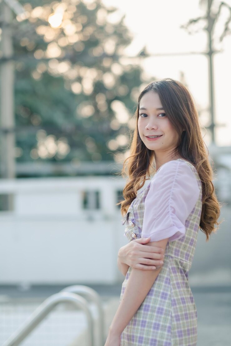 Photo 外で立っている笑顔の若い女性の肖像画