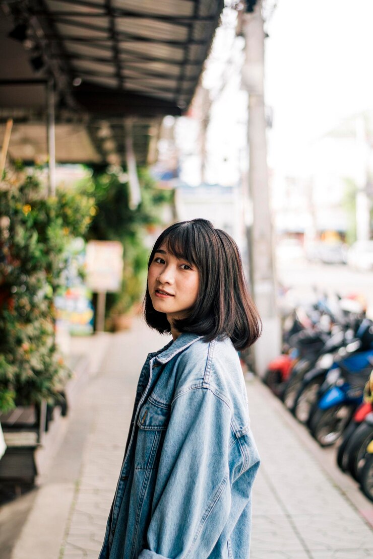 Photo 外で立っている笑顔の若い女性の肖像画