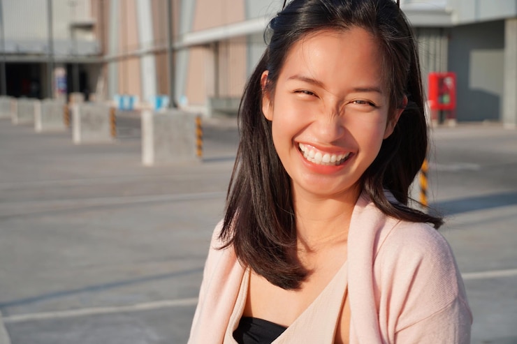 Photo 外で立っている笑顔の若い女性の肖像画