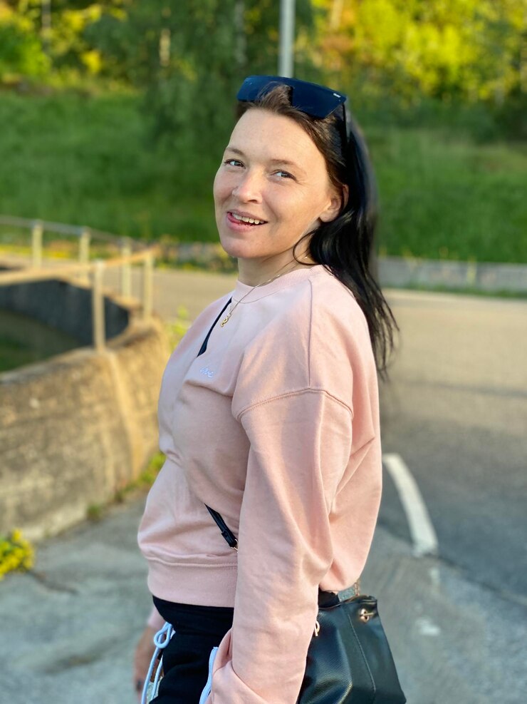 Photo 外で立っている笑顔の若い女性の肖像画