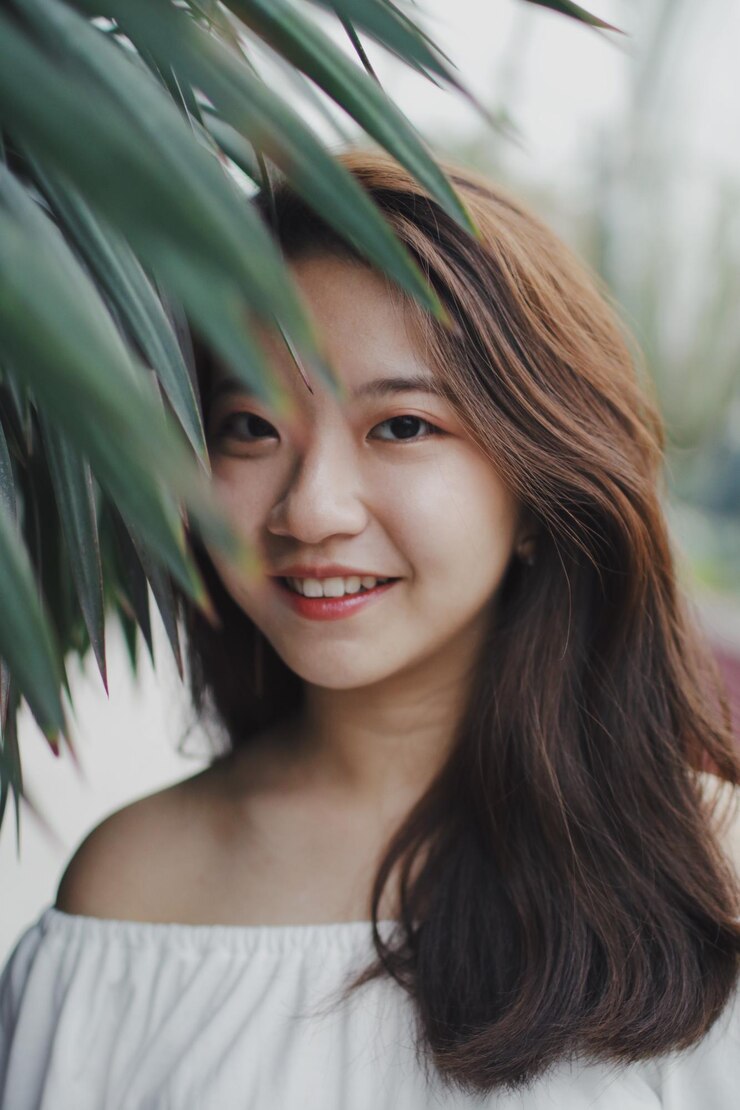 Photo 공원에서 서 있는 미소 짓는 젊은 여성의 초상화