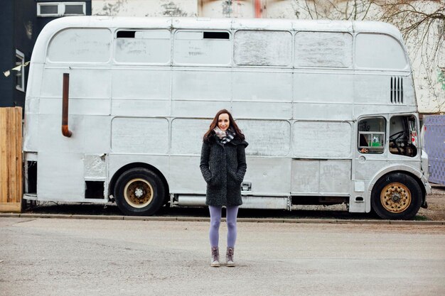 Photo portrait of smiling young woman standing on road against vehicle