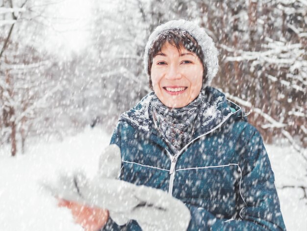 Photo portrait of smiling young woman standing in snow