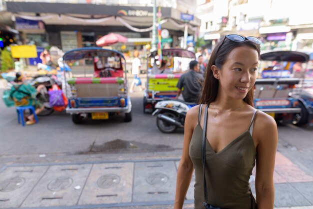 Photo portrait of smiling young woman standing on street in city