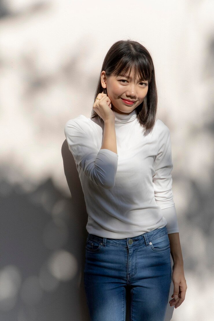 Photo 벽에 서 있는 미소 짓는 젊은 여성의 초상화