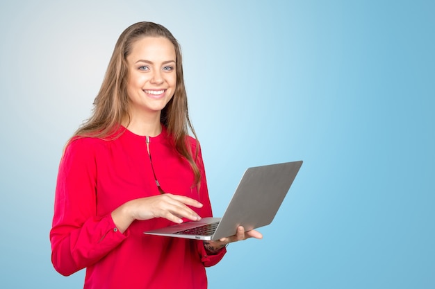 ノートパソコンで立っている笑顔の若い女性の肖像画