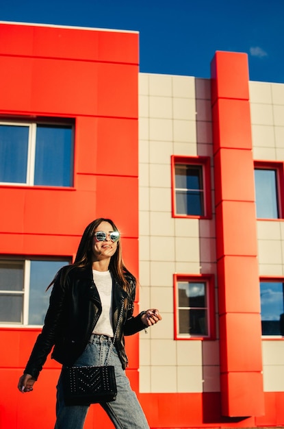 Portrait of a smiling young woman in sunglasses outdoors in the sunlight