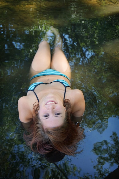Portrait of smiling young woman swimming in lake