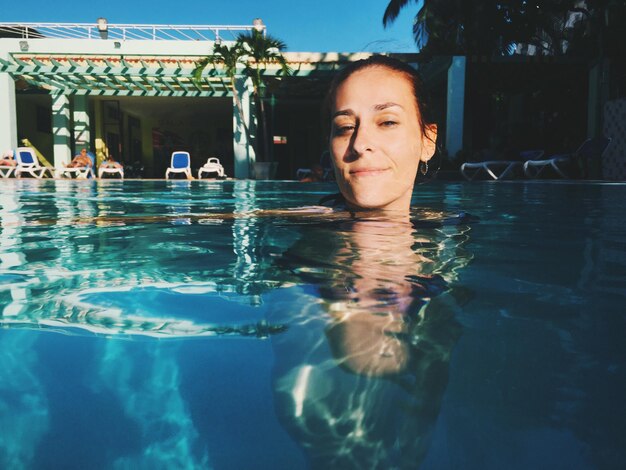 Foto ritratto di una giovane donna sorridente in piscina