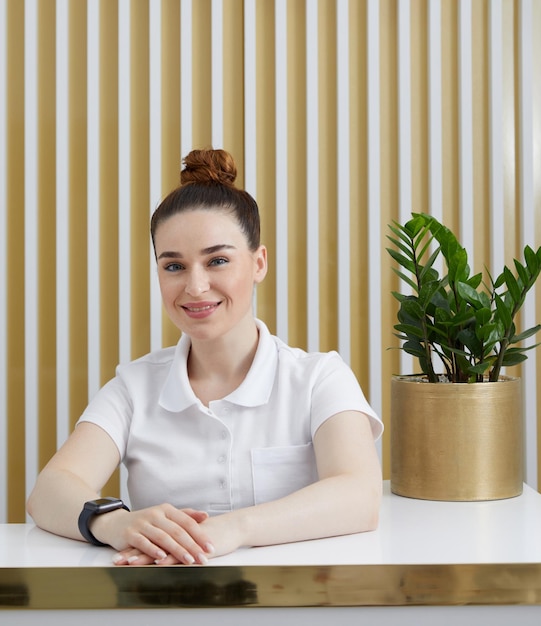 Photo portrait of smiling young woman using mobile phone while sitting on sofa at home