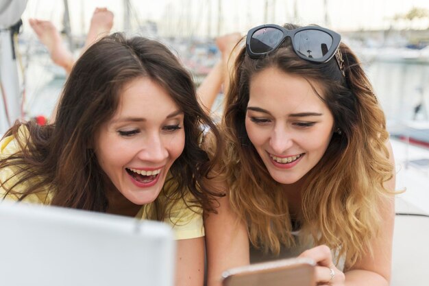 Foto ritratto di una giovane donna sorridente che usa un telefono cellulare