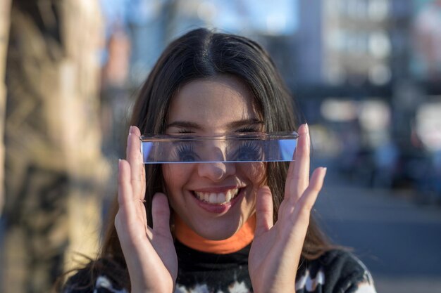 Photo portrait of smiling young woman using mobile phone